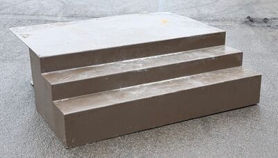 Bred lav 3 trins ståltrappe med stort repos.