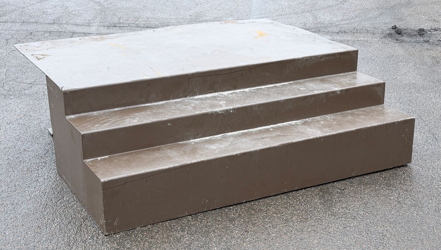 Bred lav 3 trins ståltrappe med stort repos.