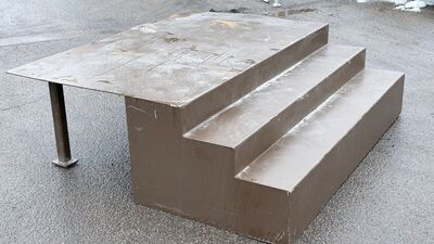 Bred lav 3 trins ståltrappe med stort repos.